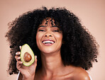 Black woman, studio portrait and avocado with smile, skincare and health with self care  wellness by background. Happy gen z model, african and fruit for natural cosmetics, healthy nutrition or diet