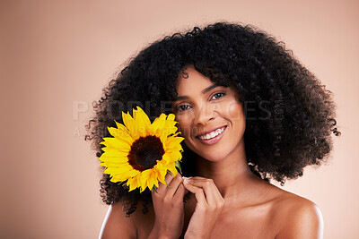 Buy stock photo Black woman, studio portrait and sunflower with smile, beauty and cosmetic wellness by beige background. African gen z model, flower and spring aesthetic with happiness, makeup and natural makeup