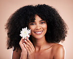 Black woman, studio portrait and flower with smile, beauty and cosmetic wellness by beige background. African gen z model, lotus plant and spring aesthetic with happiness, health and natural makeup