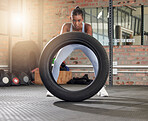 Fitness, exercise and portrait of woman with tire at gym for health and wellness with training workout. Indian athlete person focus on hard work and commitment to train for strong body goals or power