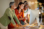 Collaboration, business and a female leader with her team, working on a computer in the office at night. Teamwork, diversity and coaching with a senior woman manager training her staff at work