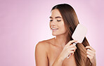 Beauty, woman and smile, hair care and brush, skin glow with skincare, face and dermatology on pink background. Keratin treatment, shine and natural cosmetics with hands, hairstyle and mockup space