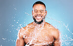 Shower, athlete and water splash for black man cleaning, hygiene and skincare isolated in studio blue background. Portrait, aqua and model with washing smooth skin with glow smile closed eyes