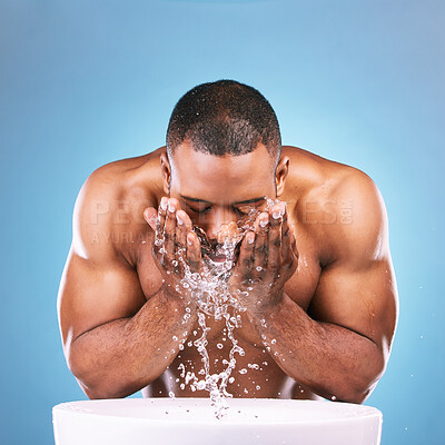 Buy stock photo Water, cleaning and beauty with a black man in studio on a blue background for hygiene or hydration. Splash, face abd skincare with a male washing his skin in the bathroom for natural body care