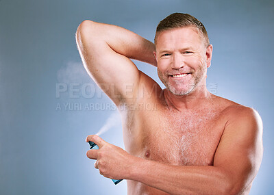 Buy stock photo Man, armpit and deodorant in skincare hygiene, grooming or smelling fresh against a studio background. Portrait of elderly male smiling and spraying under arms for aroma or clean cosmetics on mockup