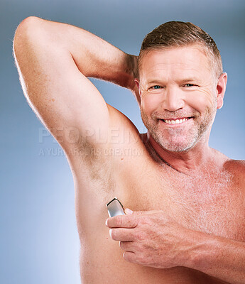 Buy stock photo Electric razor, senior man armpit and portrait of an elderly model smile for grooming wellness and shave. Hygiene, cleaning and body hair maintenance of a person in isolated blue background studio 