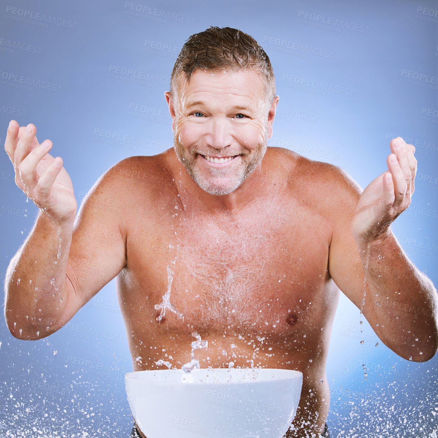 Buy stock photo Skincare, water and man washing face in a studio for a beauty, natural and cosmetic routine. Happy, smile and portrait of a senior male model doing a facial cleansing treatment by a purple background