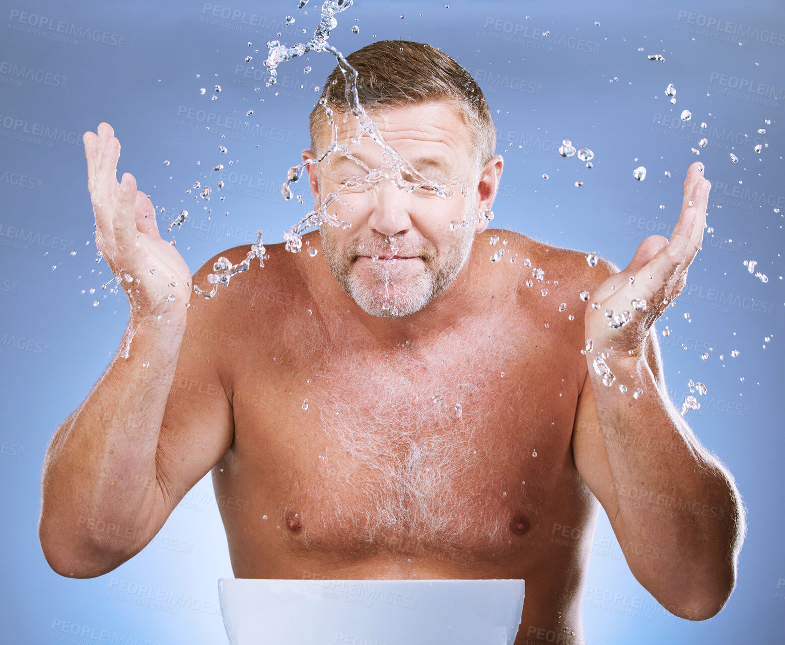 Buy stock photo Man cleaning face, hands and water drop, hygiene and grooming with clean facial on blue background. Mature male washing skin, basin and beauty with natural cosmetic care, wellness and dermatology