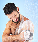 Cleaning, shower and man with sponge, water splash and soap in studio for wellness, hygiene and grooming. Skincare, bathroom and happy male with foam, cosmetics and washing body on blue background