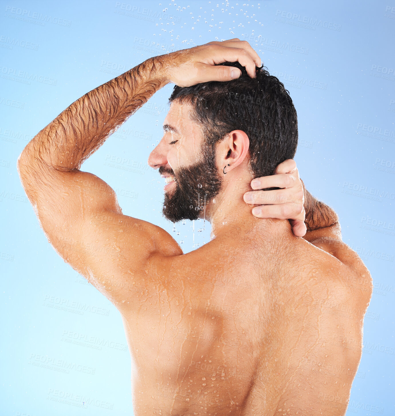 Buy stock photo Hair, washing and man in studio for skincare, grooming and hygiene against blue background. Haircare, body care and guy model relax in shower, happy and isolated on water splash, cosmetic or wellness