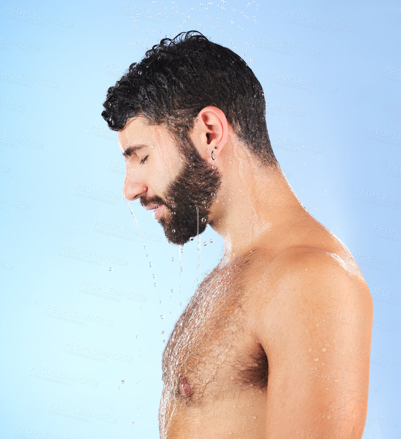 Buy stock photo Man, shower and profile of a model in water for cleaning, skincare and hygiene wellness. Isolated, blue background and studio with a young person in bathroom for dermatology and self care routine