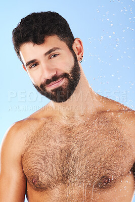Buy stock photo Shower, portrait and man in studio for skincare, grooming and hygiene on a blue background. Face, body care and guy model relax in a bathroom, happy and isolated on water splash, cosmetic or wellness