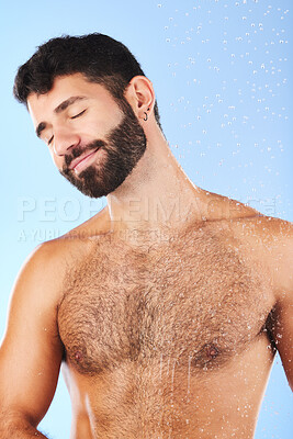 Buy stock photo Body care, relax and man in studio for skincare, grooming and hygiene against blue background. Luxury, bathroom and guy model happy in shower, smile and isolated on water splash, cosmetic or wellness