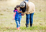 Grandmother, happy girl and nature walk of a kid with senior woman in the countryside. Outdoor field, grass and elderly female with child on a family adventure on vacation with happiness and fun 