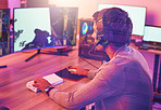 Computer gaming, man and headphones for esports, online games and virtual competition in dark room. Gamer guy, online player and live streaming on headset in neon lighting, technology or rpg streamer