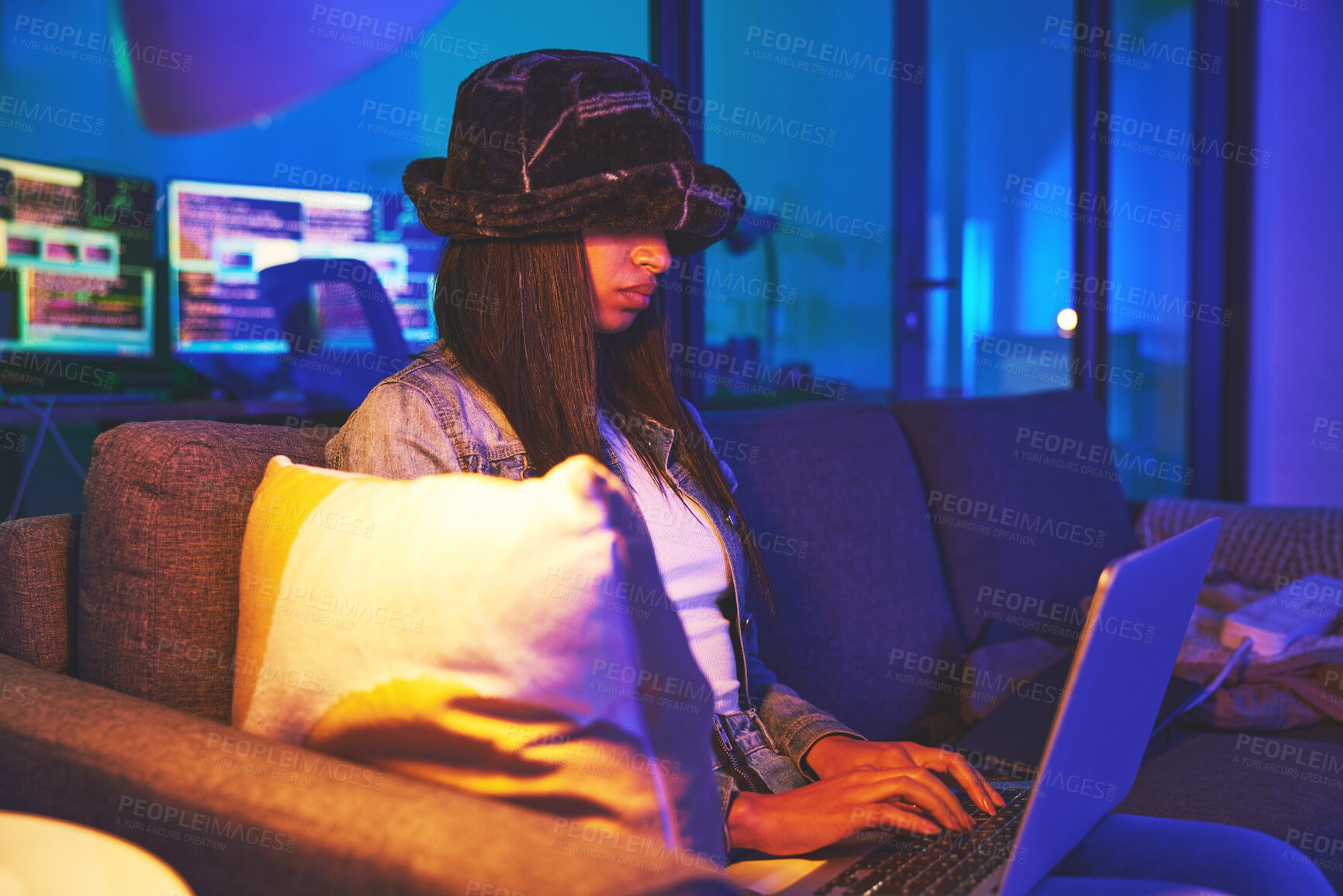 Buy stock photo Woman, hacker and programmer typing on laptop in home at night in neon to hack software. Cybersecurity sofa, ransomware phishing and female coder coding on computer for hacking database with malware.