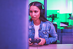 Gamer, headphones and woman on computer in home at night in green neon light for web esports. Gaming, technology and female with controller playing online games, multiplayer or video game in house.