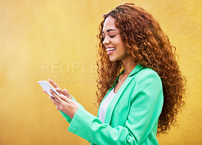 Buy stock photo Woman, phone and typing on yellow background for communication, social media and tech chat. Happy female model, smartphone and network connection for mobile app, digital contact and search website