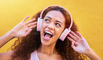 Buy stock photo Music, thinking and wow with a black woman listening to the radio outdoor on a yellow wall background. Headphones, energy and face with an attractive young female streaming audio sound for fun