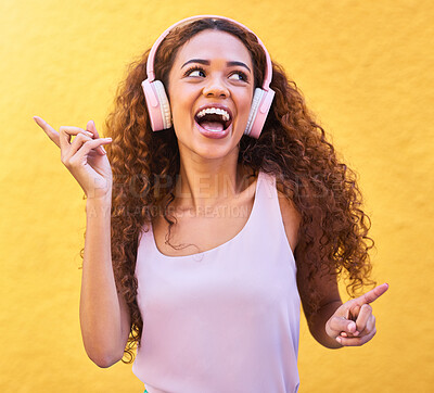 Buy stock photo Music, thinking and dance with a black woman listening to the radio outdoor on a yellow wall background. Headphones, energy and face with an attractive young female streaming audio sound for fun