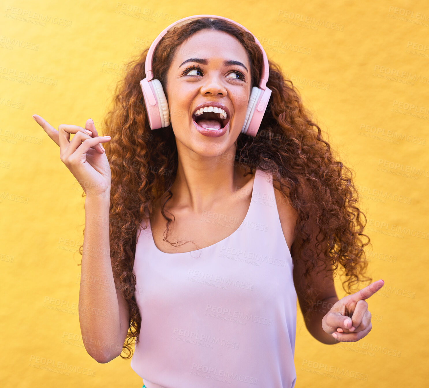 Buy stock photo Music, thinking and dance with a black woman listening to the radio outdoor on a yellow wall background. Headphones, energy and face with an attractive young female streaming audio sound for fun