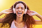 Music, portrait and freedom with a black woman listening to the radio outdoor on a yellow wall background. Headphones, energy and face with an attractive young female streaming audio sound for fun