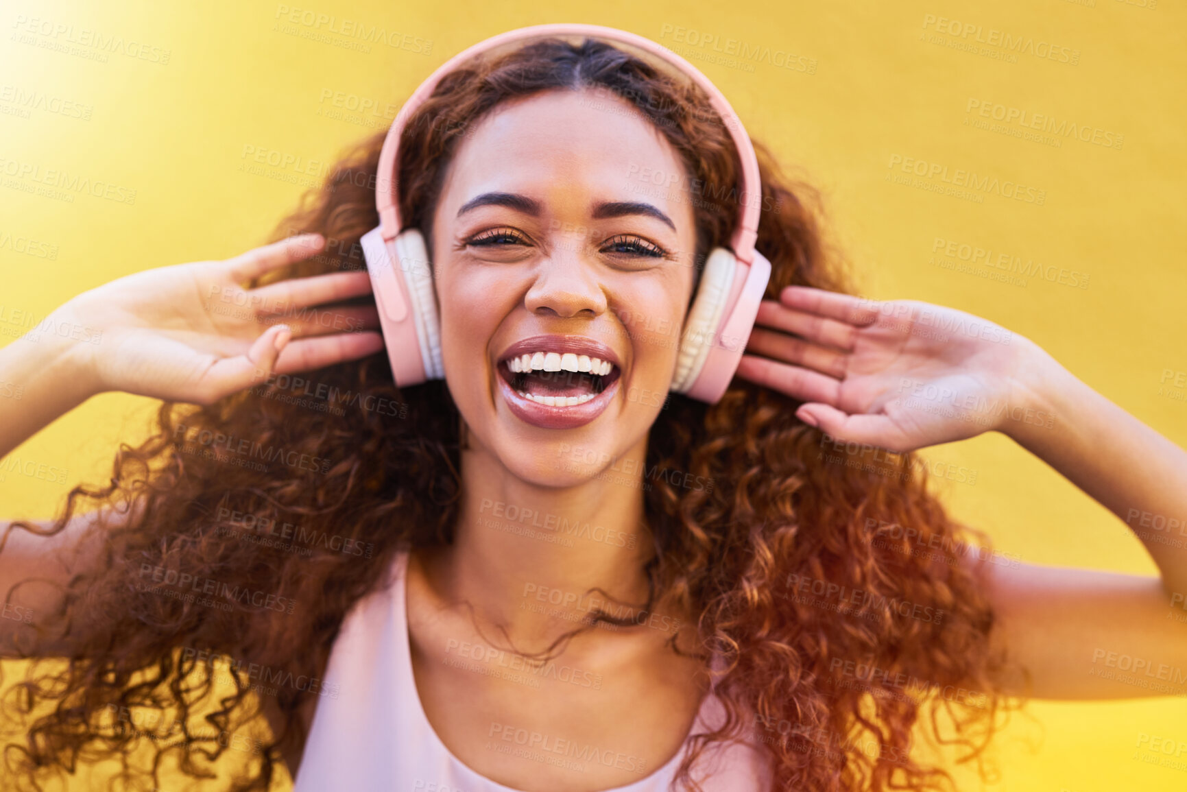 Buy stock photo Music, portrait and freedom with a black woman listening to the radio outdoor on a yellow wall background. Headphones, energy and face with an attractive young female streaming audio sound for fun