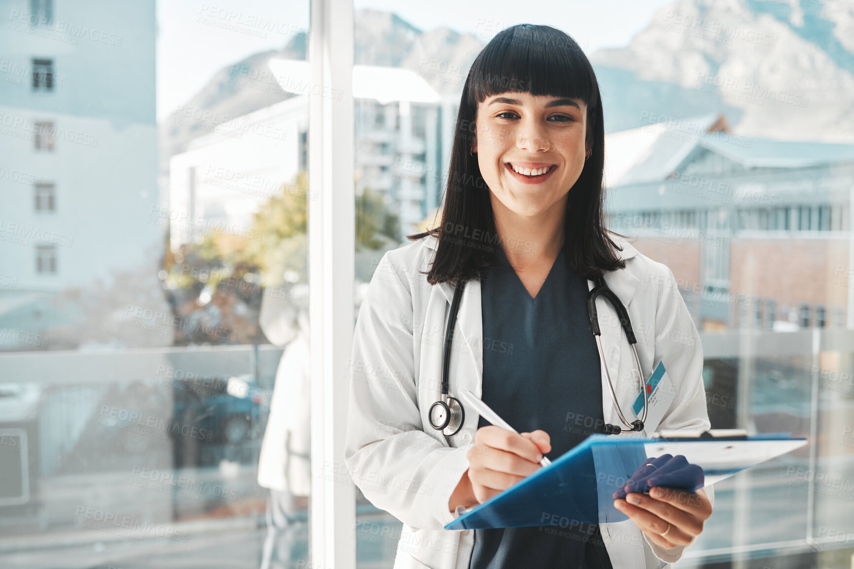 Buy stock photo Woman, doctor and portrait smile writing on clipboard by window for healthcare planning, strategy or notes. Female medical expert smiling with paperwork, prescription or medicare details at hospital
