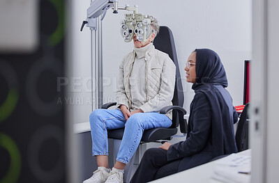 Buy stock photo Vision, eye exam and senior woman with optometrist in clinic for testing, eyesight and optical assessment. Optometry, healthcare and Muslim optician with patient, phoropter and medical tool for eyes