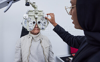 Buy stock photo Eye exam, vision and woman with Muslim optometrist in clinic for test, eyesight and optical assessment. Optometry, healthcare and optician with elderly patient on phoropter, lens and medical machine