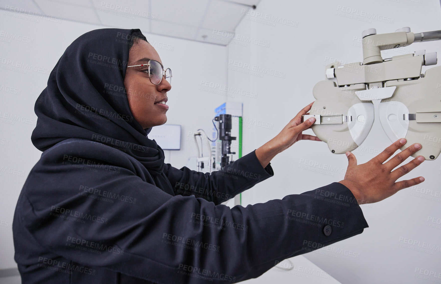 Buy stock photo Optometry, vision and healthcare with an arabic woman at work in her eyecare office for testing. Hospital, medical or eye exam and a muslim female working with equipment for diagnosis at an optician 