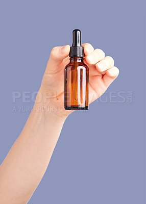 Buy stock photo Hands, skincare and serum bottle in studio isolated on a purple background. Product, dermatology and woman or female model with hyaluronic acid, essential oil or cosmetics for aesthetics and beauty.