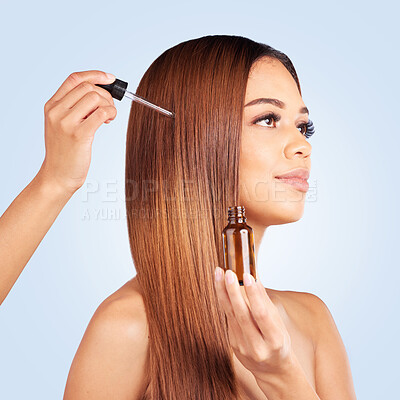Buy stock photo Beauty, hair care and woman with serum in studio isolated on a blue background. Cosmetics, thinking and female model apply hyaluronic acid, essential oil or hairstyle moisturizer for salon treatment.