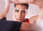 Portrait, hands and frame with black man, aesthetic and confident guy against studio background. Face, queer person and male with framing for perspective, fashion or creative with makeup or cosmetics