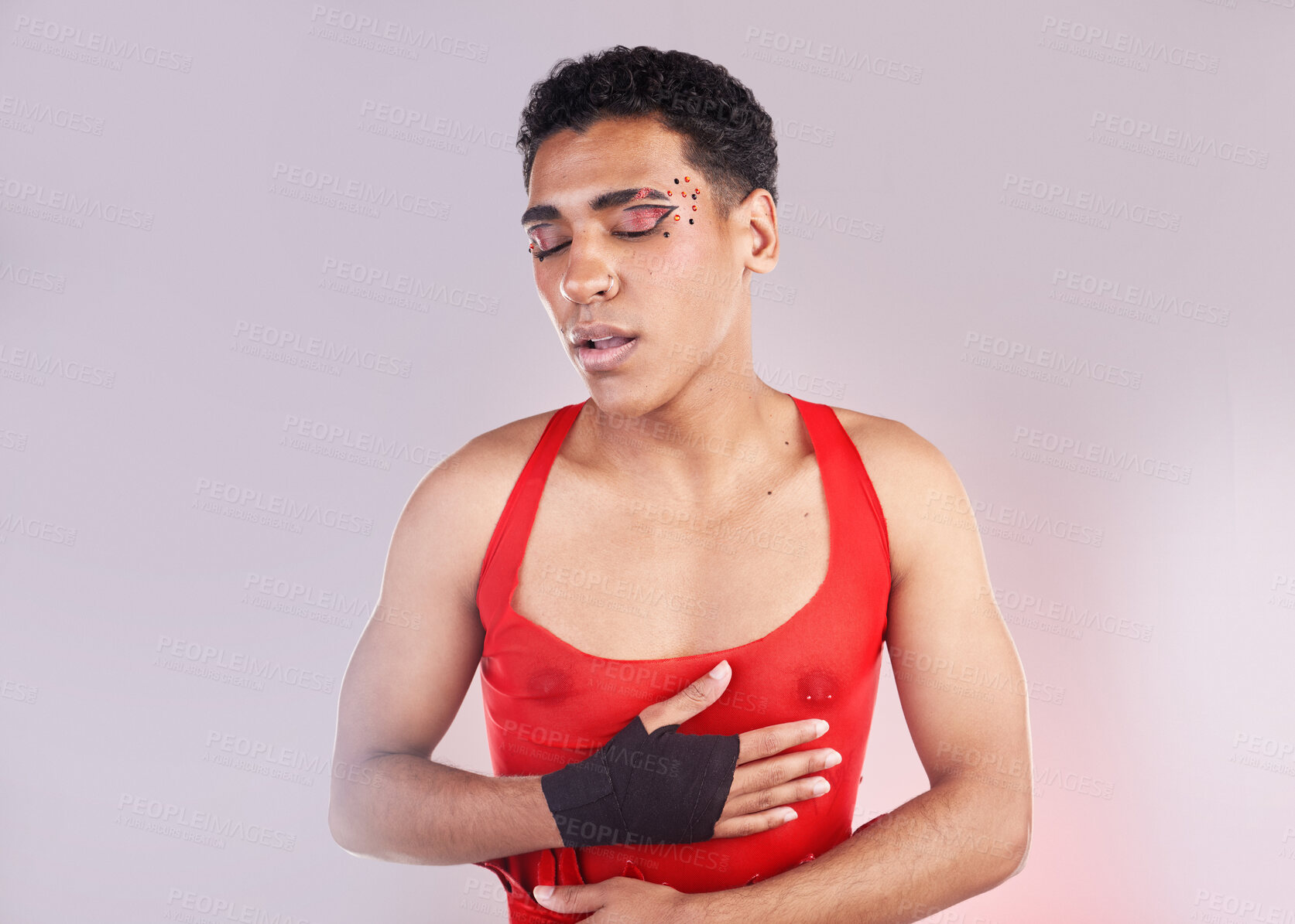 Buy stock photo Punk, fashion and makeup man isolated on studio background for creative, art and gen z cosmetics. Gay, lgbtq and queer model or black person with danger, red and fight for love and beauty aesthetic