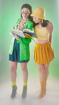 Vintage woman students, books and studio with 80s fashion, retro and learning together with trippy green aesthetic. Gen z model friends, clothes and teacher cosplay with reading by blurred background