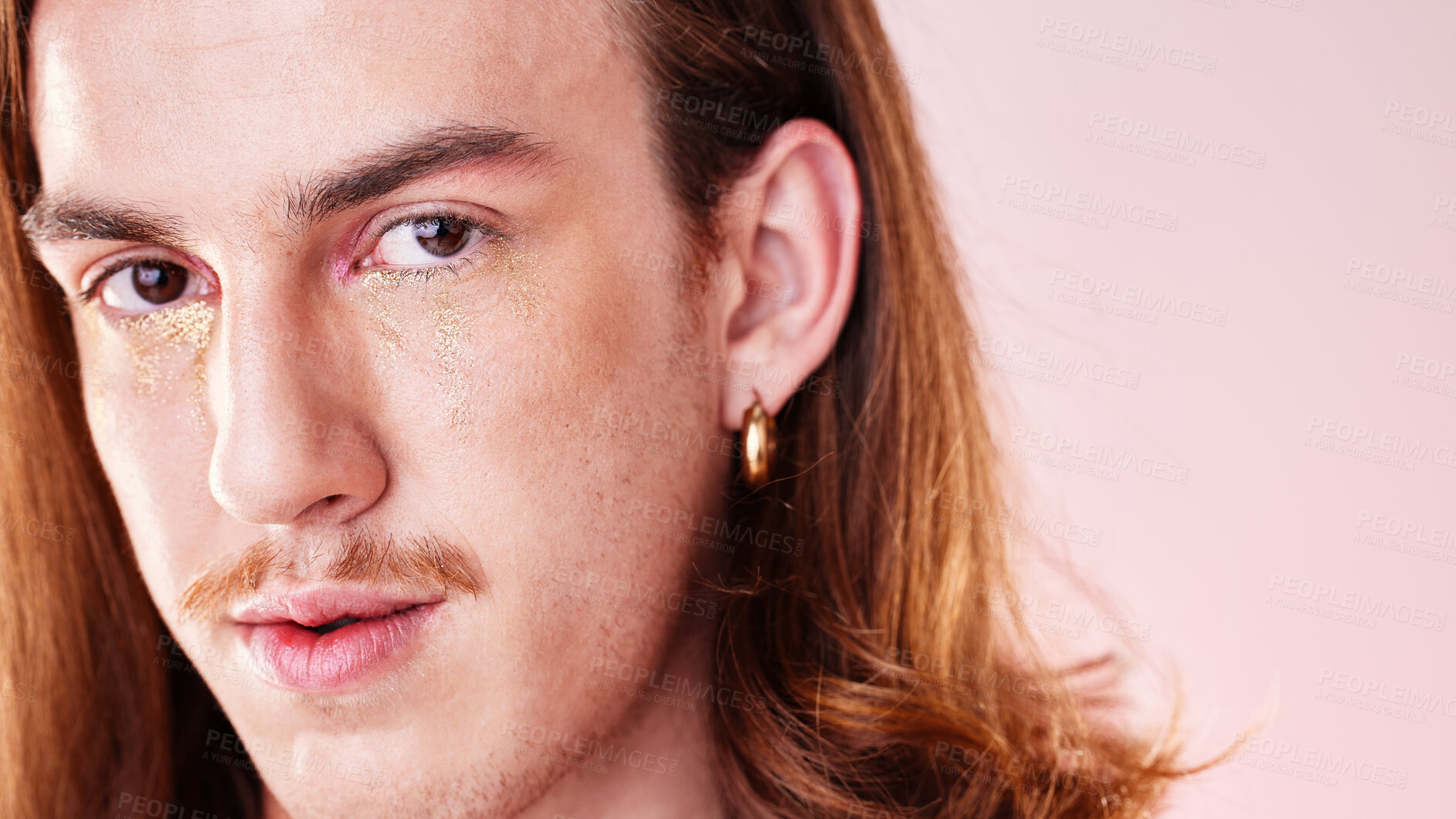 Buy stock photo Face portrait, beauty and man with makeup in studio isolated on a pink background. Gen z, lgbtq and gay, queer or homosexual young male model with gold glitter cosmetics for aesthetics and skincare.