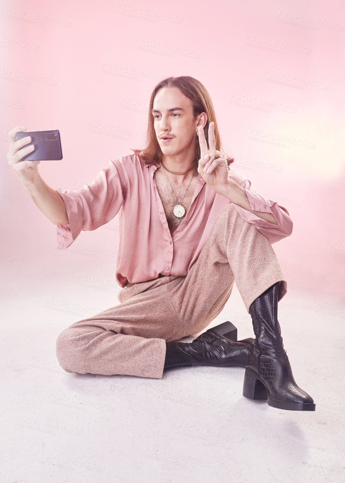 Buy stock photo Selfie, peace and fashion with a gay man in studio on a pink background for lgbt inclusion or pride. Transgender, non binary and photograph with a male model sitting on the floor for trendy style