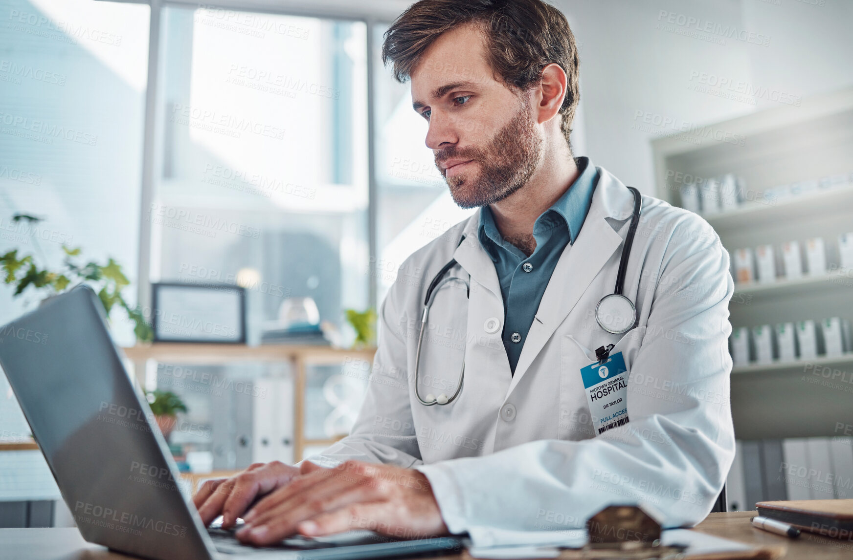 Buy stock photo Man, doctor and laptop typing in healthcare research, communication or social media at office desk. Male medical expert working on computer in online search, browsing or chatting on tablet at clinic