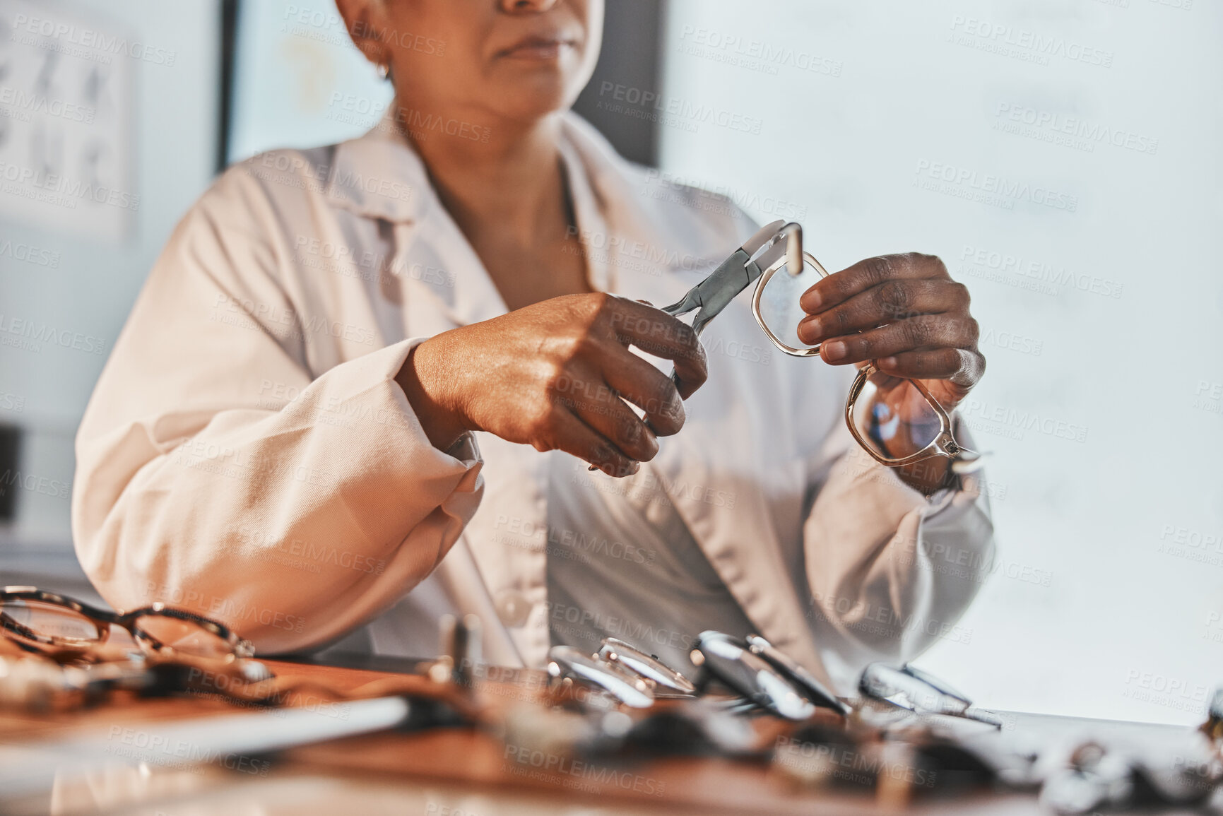 Buy stock photo Senior optometrist, hands and tools with glasses, maintenance and frame design planning at desk. Elderly optician, spectacles designer and eye product in workplace for health, small business and goal