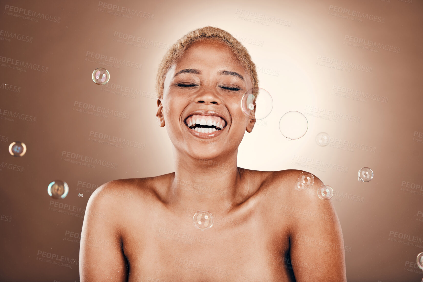 Buy stock photo Cosmetics, black woman and skincare with bubbles, laughing and brown studio background. African American female, lady and beauty with dermatology, aesthetic and wellness with soap bubble or soft skin