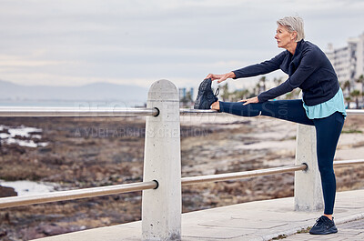 Buy stock photo Senior woman, fitness and stretching at beach sidewalk for energy, wellness and healthy workout on sky mockup. Elderly lady, exercise and warm up legs at sea promenade for sports, thinking or running