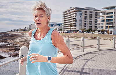 Buy stock photo Senior woman, fitness and running at beach promenade for energy, wellness and healthy workout in Miami. Elderly female, earphones and runner at sea for sports, cardio exercise and marathon training 