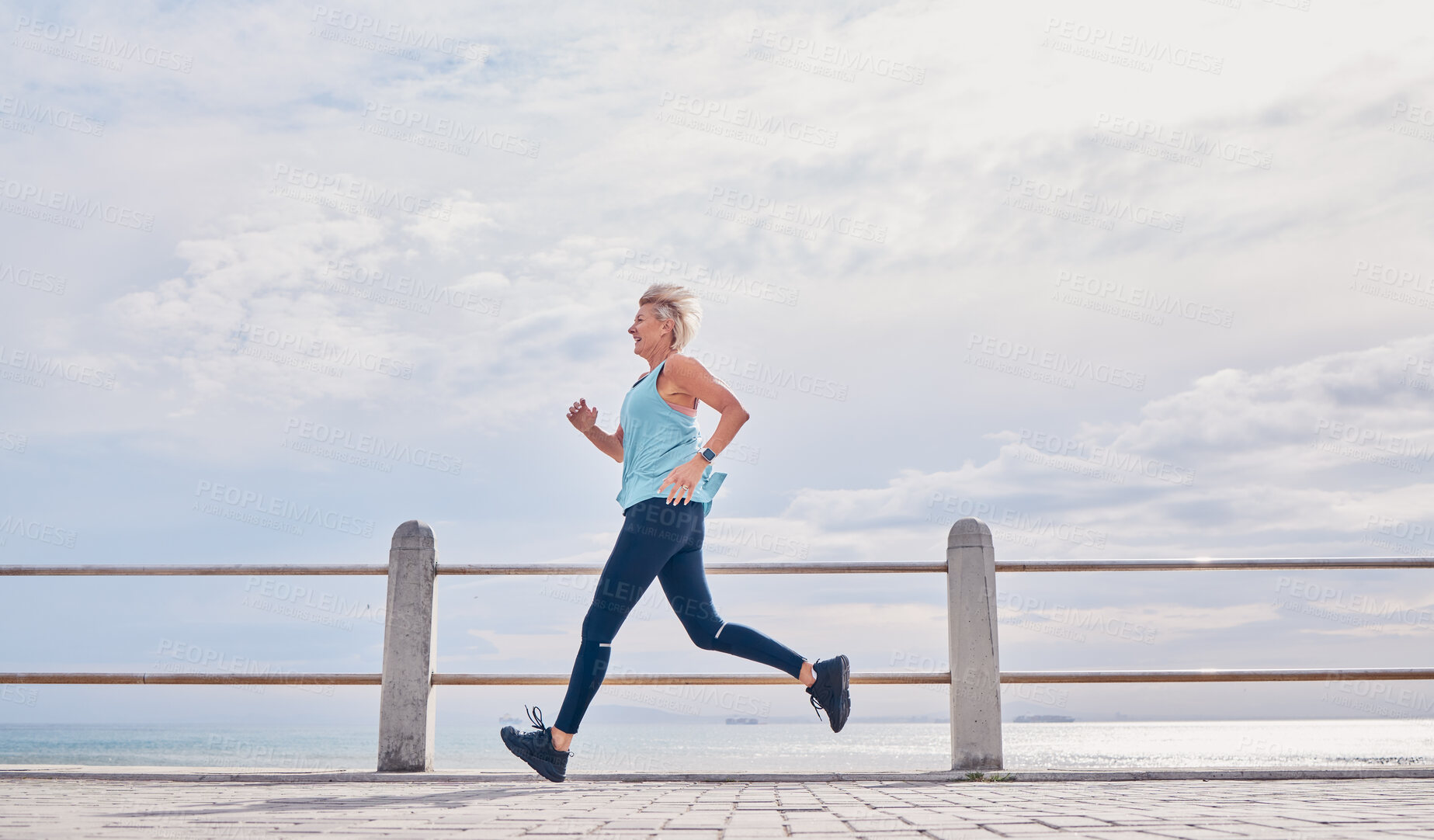 Buy stock photo Senior woman running outdoor at on sky mockup at beach promenade for energy, health and cardio workout. Elderly female, exercise and runner at ocean for sports training, fitness and healthy marathon