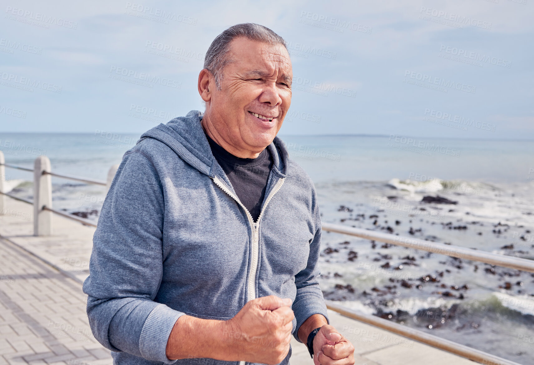 Buy stock photo Workout, senior man and running at beach promenade for energy, wellness or cardio marathon. Elderly male, exercise and runner at sea for sports training, healthy fitness or smile of happy strong body