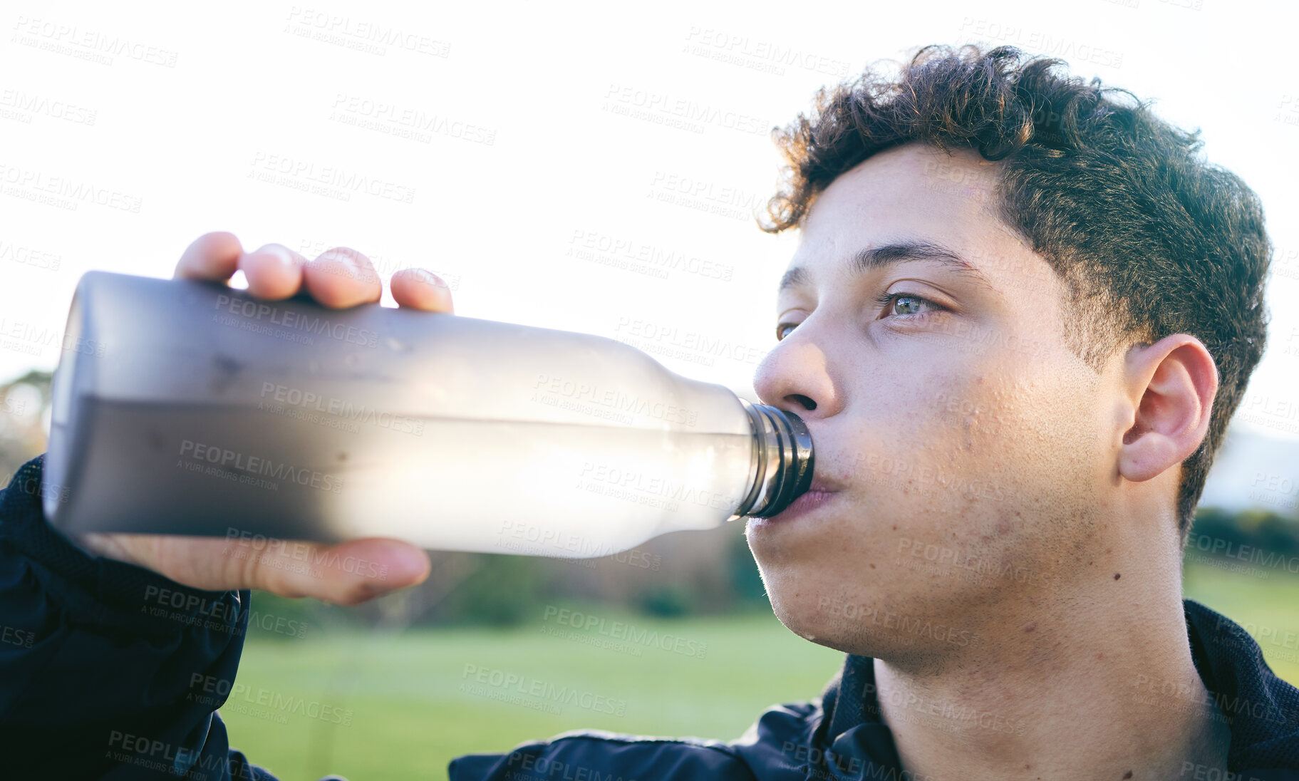 Buy stock photo Fitness, drinking water and man in nature after workout, exercise or running outdoors. Health, wellness and face of thirsty male athlete with liquid for hydration after training, cardio or exercising