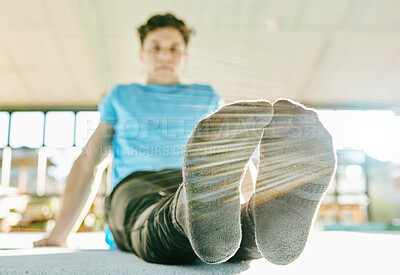 Buy stock photo Feet, fitness and man doing a stretching exercise before training in gym or sport center. Sports, health and male athlete doing leg warm up workout for flexibility and balance for gymnastics practice