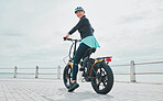 Back, portrait and bike with senior woman, promenade and exercise for healthy lifestyle, balance and happiness. Face, mature female and athlete cycling, ocean and mockup with training and fitness