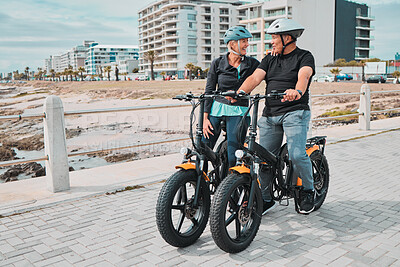 Buy stock photo Senior couple, electric bike and ride by the beach for fun bonding activity or travel together in the city. Happy elderly man and woman enjoying cruise on electrical bicycle for trip in Cape Town