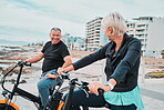 Mature people, electrical or bike by ocean, beach or sea in bonding transportation, clean energy or sustainability travel. Ebike, electricity or eco friendly bicycle for happy couple or cycling woman